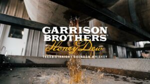 Garrison Brothers Making of Video thumbnail of whiskey pouring out of barrel with logo overlayed on top
